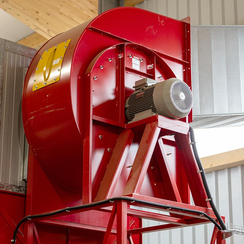 Eine große rote Gebläsemaschine in einem Silo.